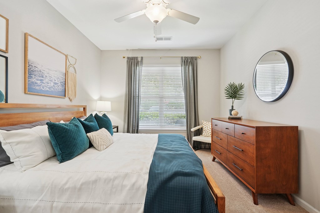 A bedroom with a large bed and a ceiling fan.