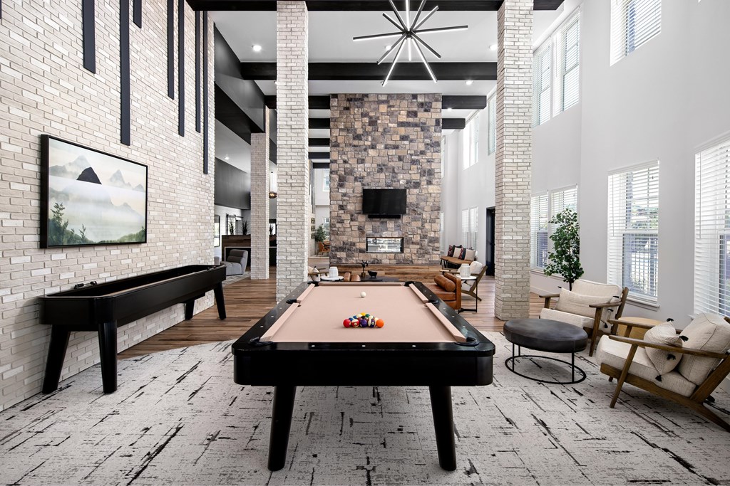 A pool table in a room with a brick wall and a fireplace.