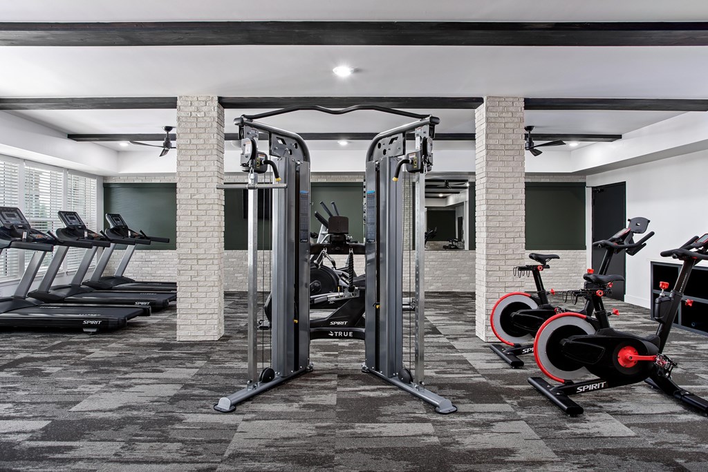 A gym with a treadmill, a weight machine, and a stationary bike.