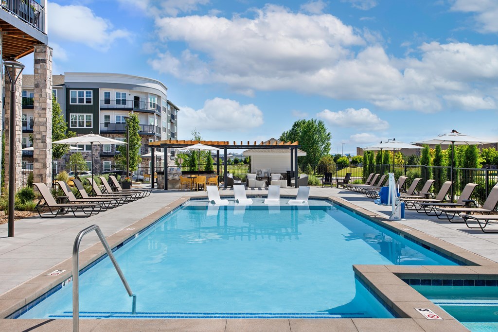 A large outdoor swimming pool surrounded by lounge chairs.