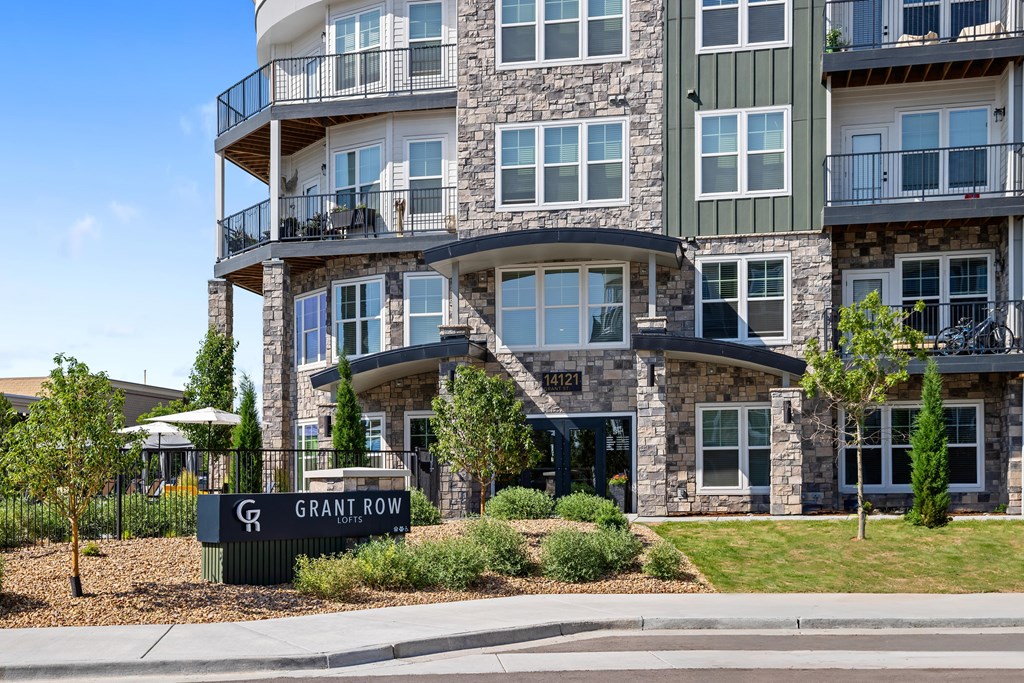 A large stone building with a balcony and a sign that says Grant Row.