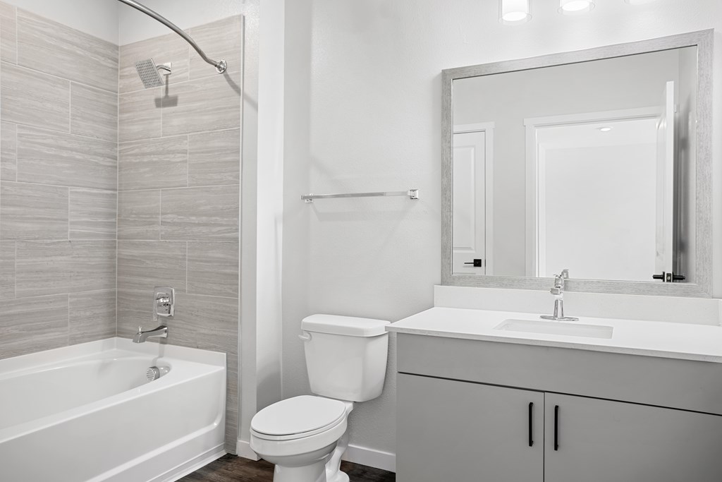 A white bathroom with a toilet, sink, and bathtub.