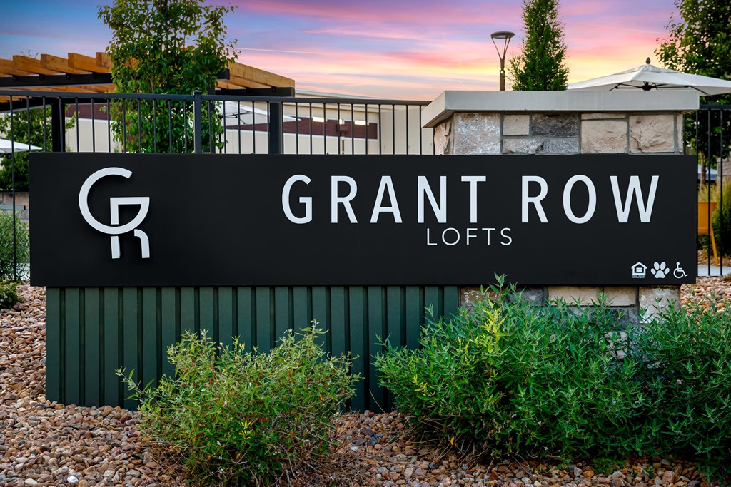 A sign for Grant Row Lofts is displayed in front of a building.