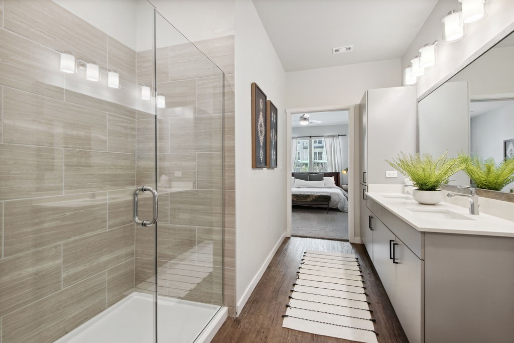 a bathroom with a shower and a sink and a mirror