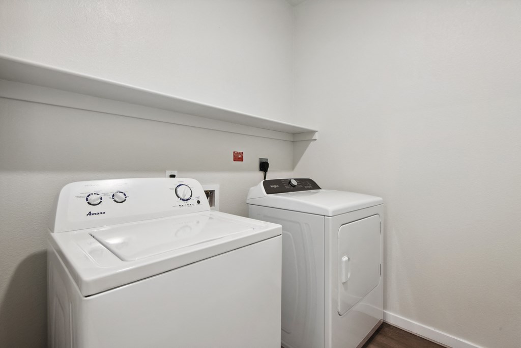an empty laundry room with a washer and dryer in it and a white