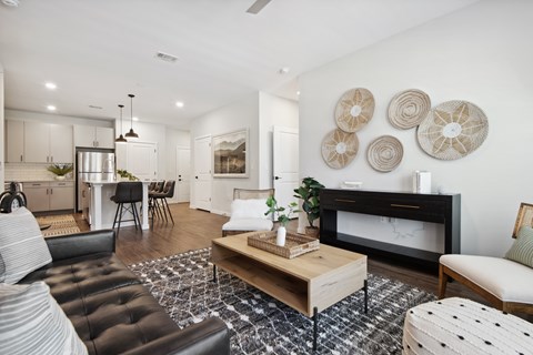 A living room with a black leather couch and a wooden coffee table.