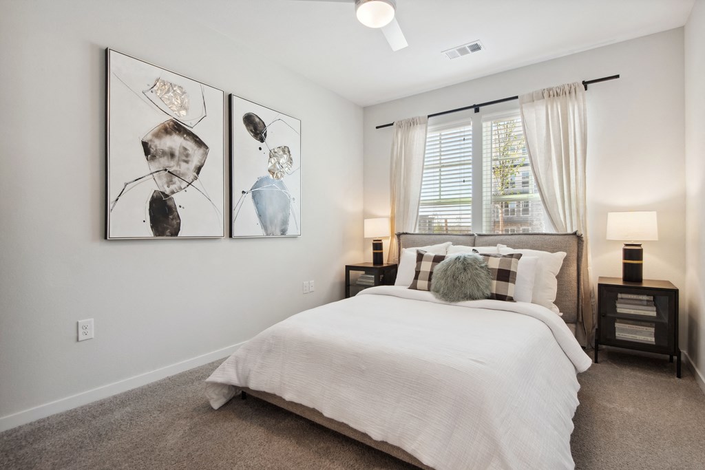 a bedroom with a bed and three paintings on the wall