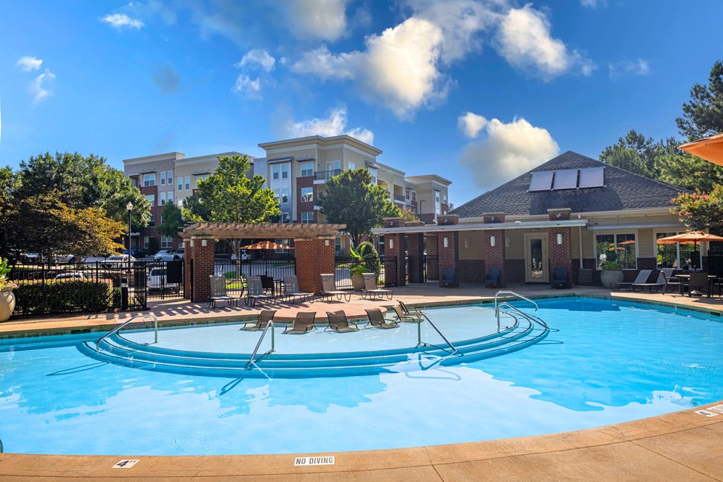 A large swimming pool with a sign that says "NO DIVING" in front of a resort.