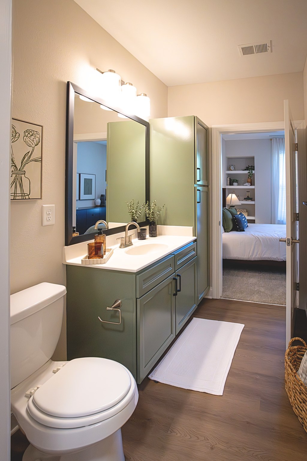 A bathroom with a white toilet and a green vanity.