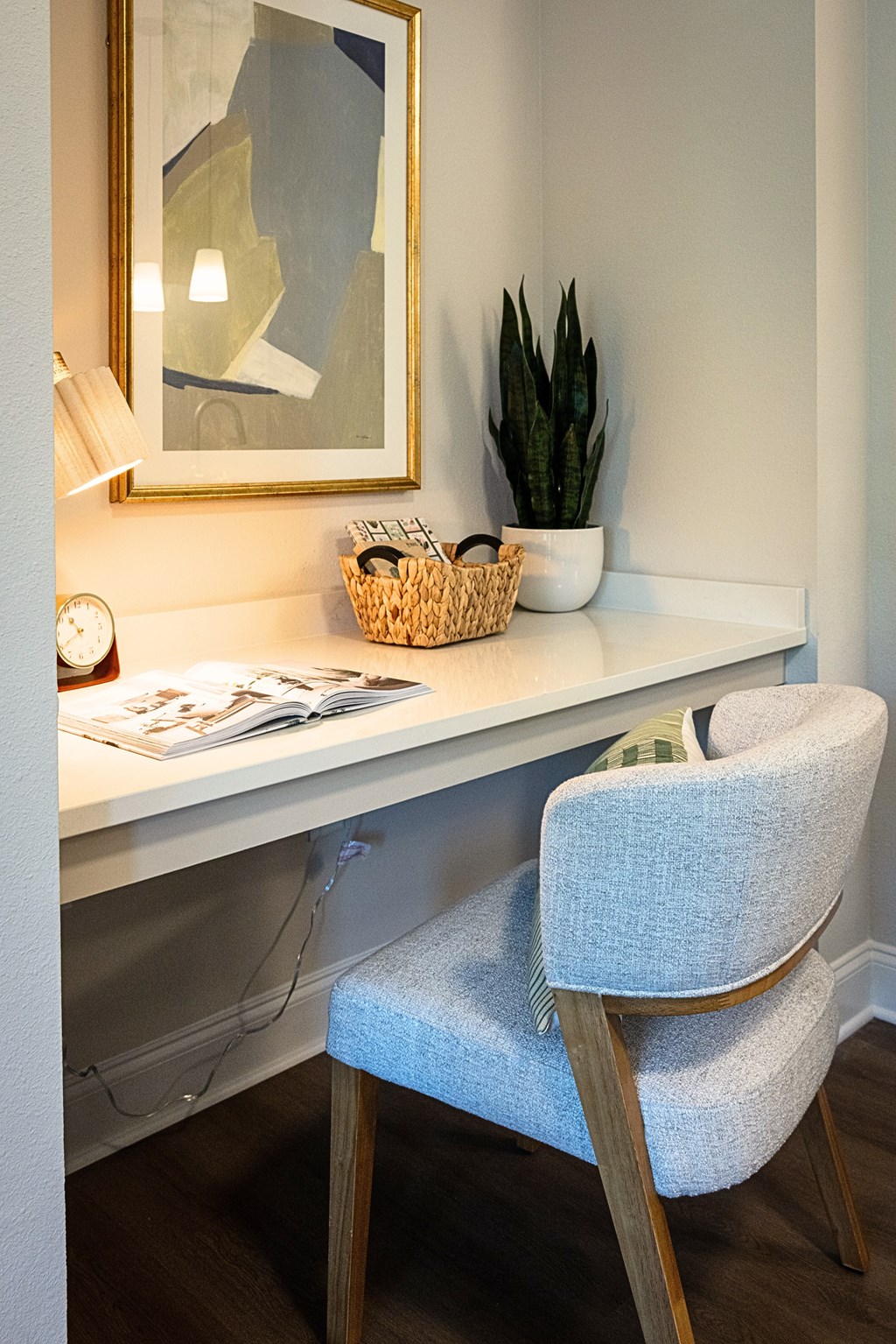 A white desk with a chair and a plant on it.