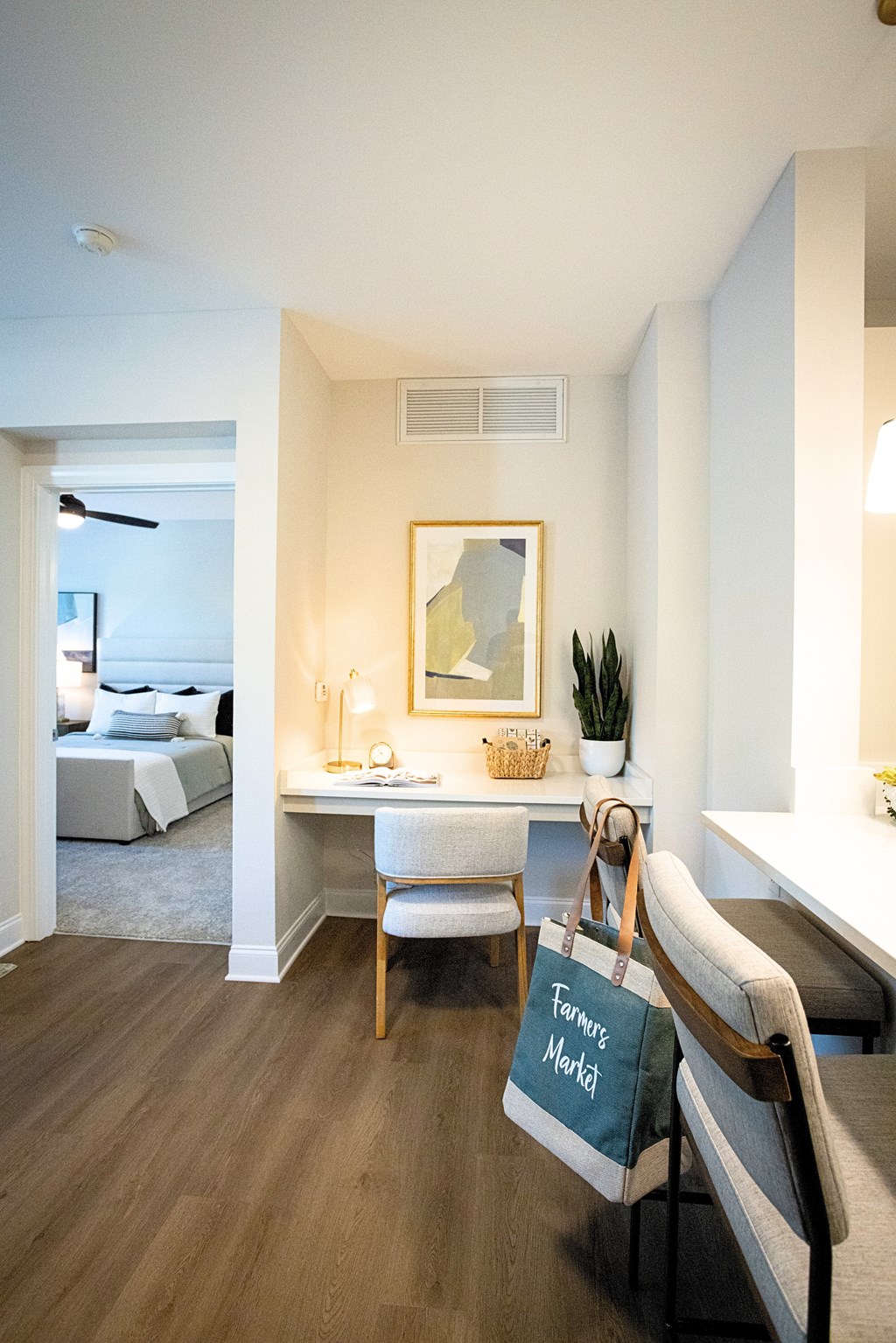 A room with a bed, desk, chair and a bag with the text "Flower Mood" hanging on the chair.