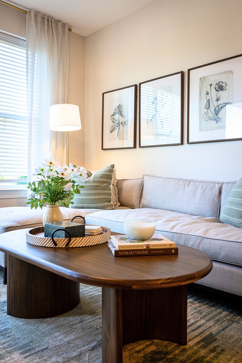 A living room with a couch, a coffee table, and pictures on the wall.