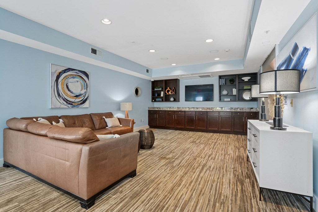 A living room with a brown couch and a white cabinet.