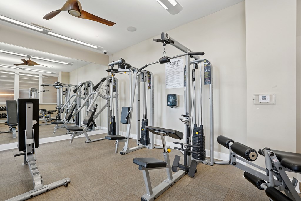 A gym with a variety of equipment including weights and machines.