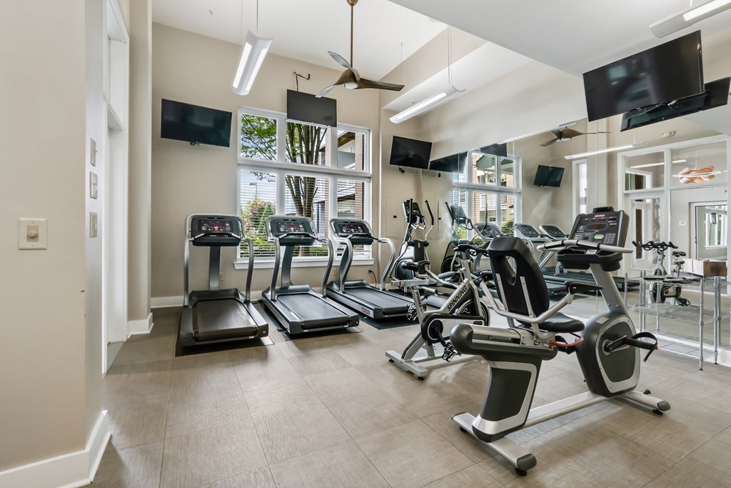 A gym with treadmills, elliptical machines, and other exercise equipment.