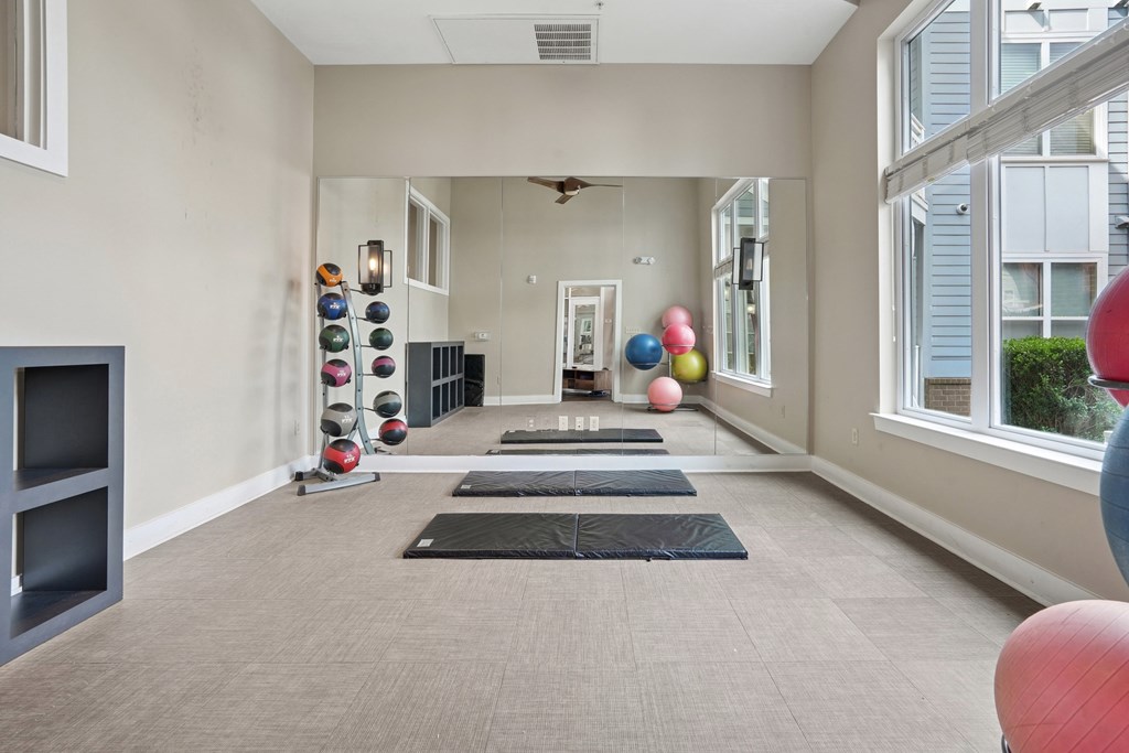 A room with exercise equipment and a mirror on the wall.