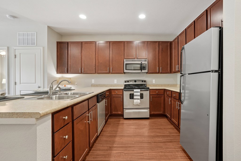 A kitchen with brown cabinets and a white fridge.