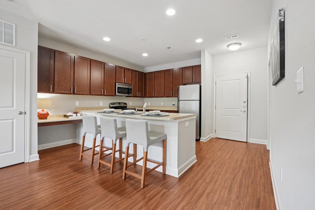 A kitchen with brown cabinets and white appliances.