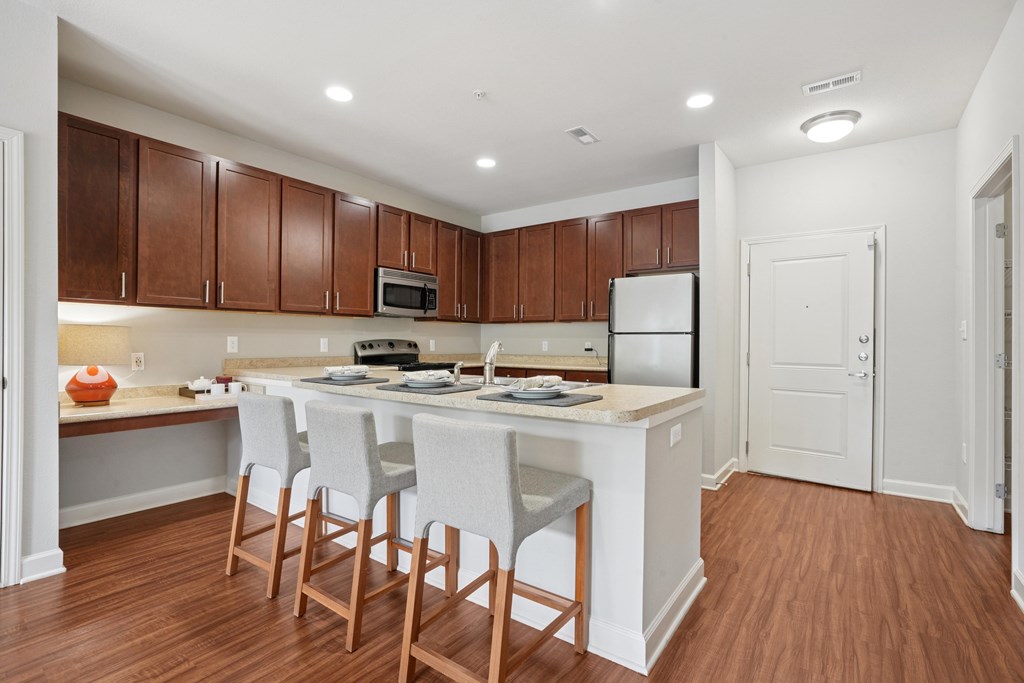 A kitchen with brown cabinets and white appliances.
