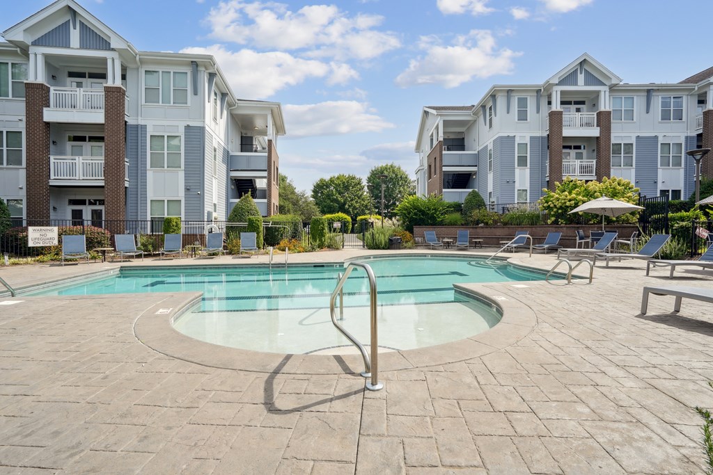 A swimming pool in a courtyard surrounded by apartment buildings.