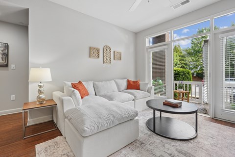 A living room with a white couch and a coffee table.