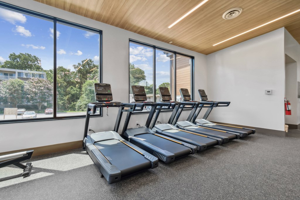 A gym with treadmills and a bench.