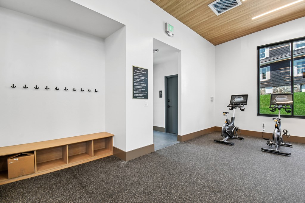 A room with exercise bikes and a window showing a green lawn.