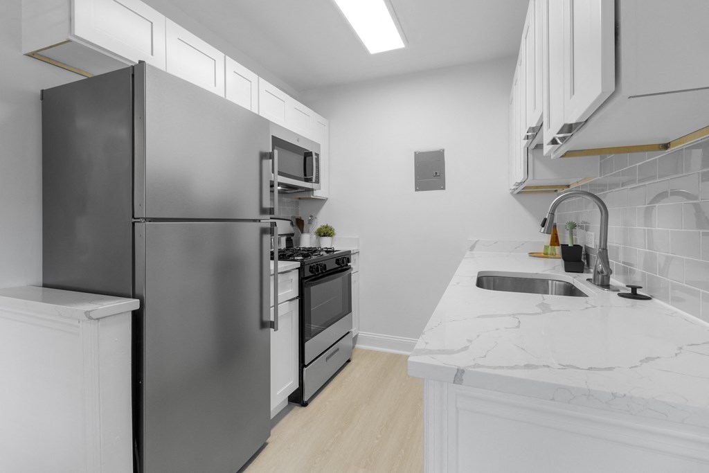 a kitchen with white countertops and stainless steel appliances