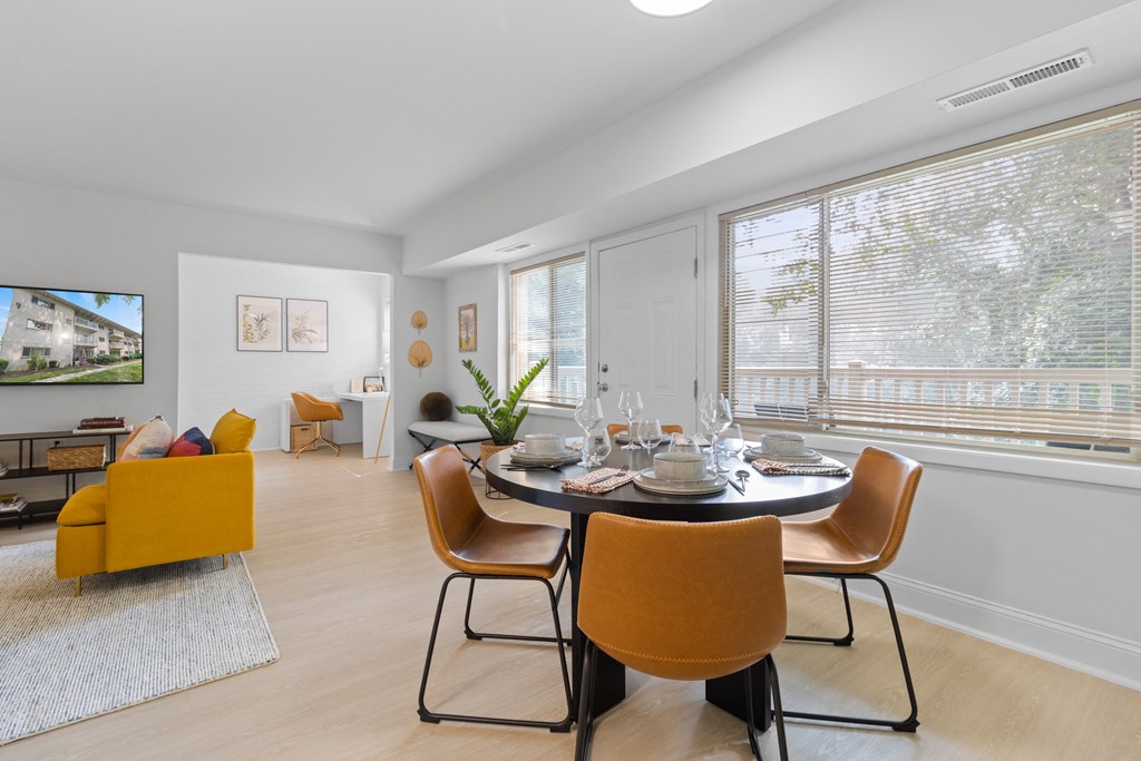 a dining room with a table and chairs and a tv on the wall