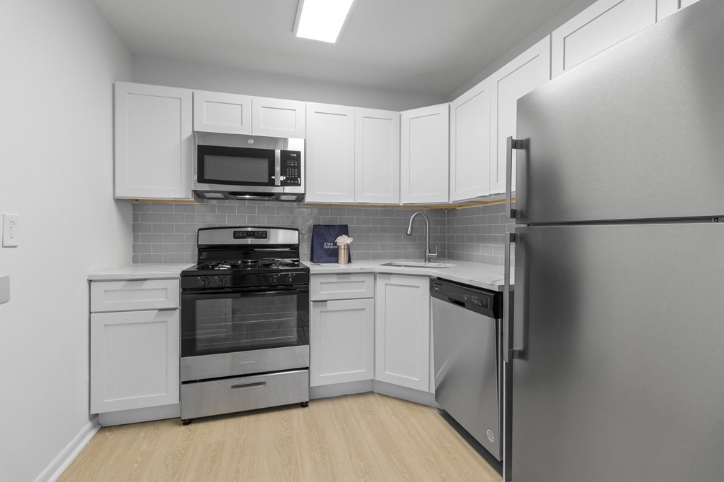 a kitchen with stainless steel appliances and white cabinets
