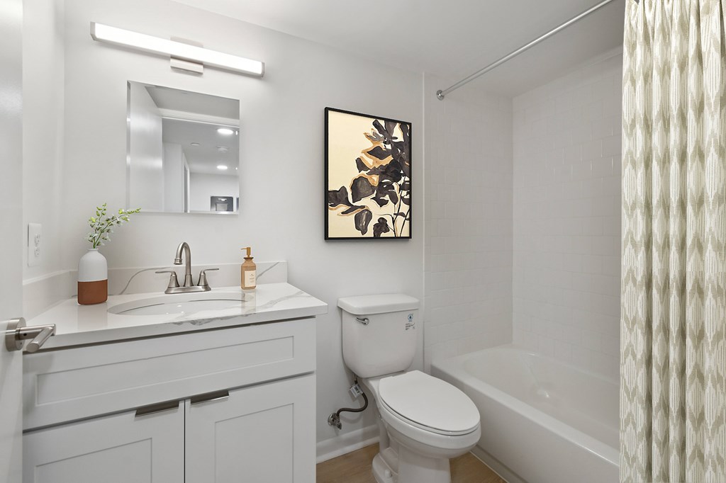 A white bathroom with a toilet, sink, and bathtub.