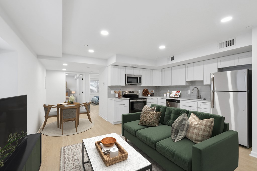A modern kitchen with a green couch and a coffee table.