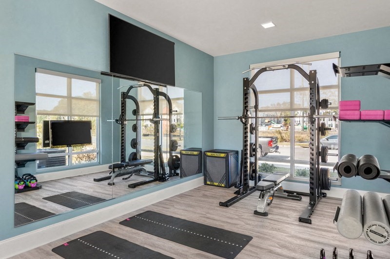 a home gym with a large window and a flat screen tv