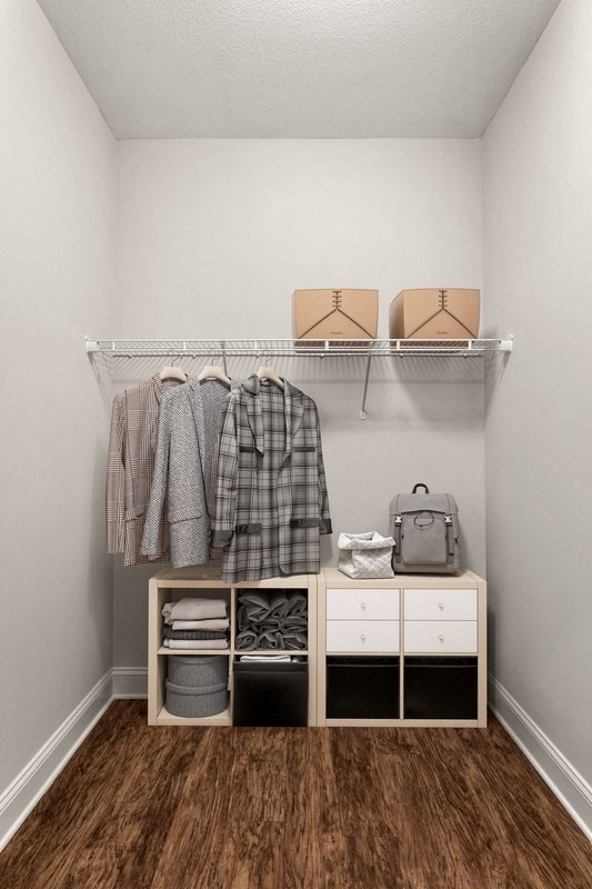 a walk in closet with a white dresser and shelves
