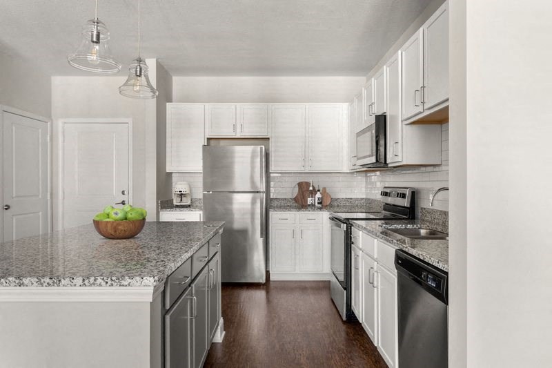 a kitchen with white cabinets and a stainless steel refrigerator