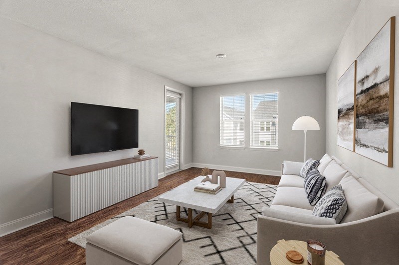 a living room with a couch coffee table and a tv on the wall