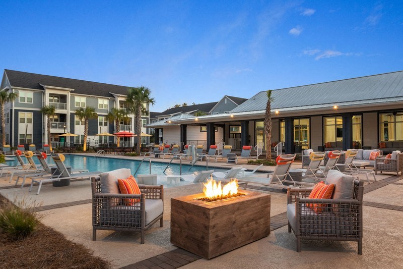 a pool with lounge chairs and a fire pit at the west end lodge apartments in beaum