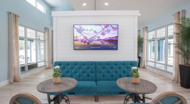 a living room with a blue couch and tables