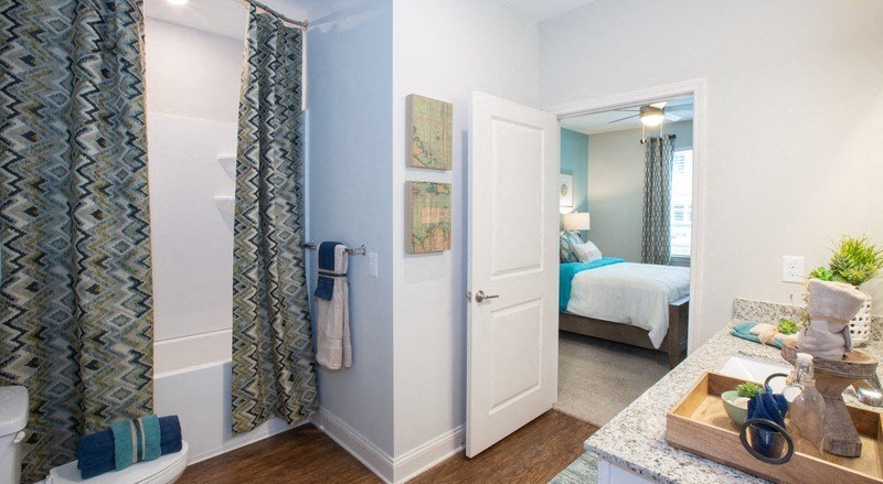 a bathroom with a shower and a door to a bedroom