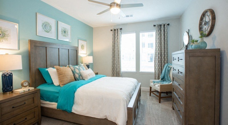 a bedroom with a bed and a ceiling fan