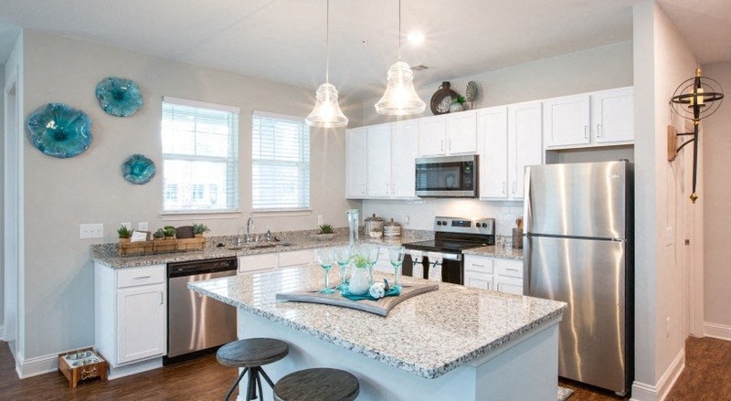 a kitchen with an island and a stainless steel refrigerator
