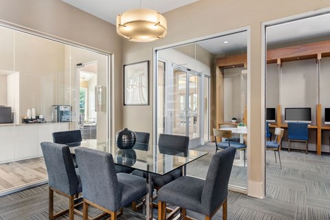 a dining room with a glass table and chairs
