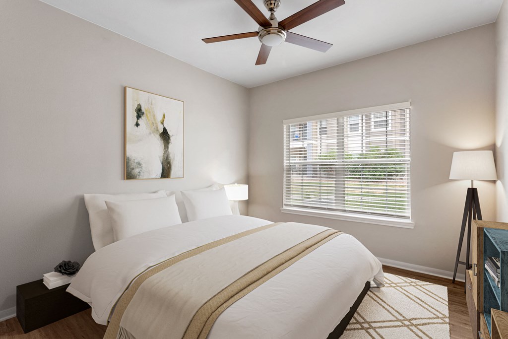 a bedroom with a large bed and a ceiling fan