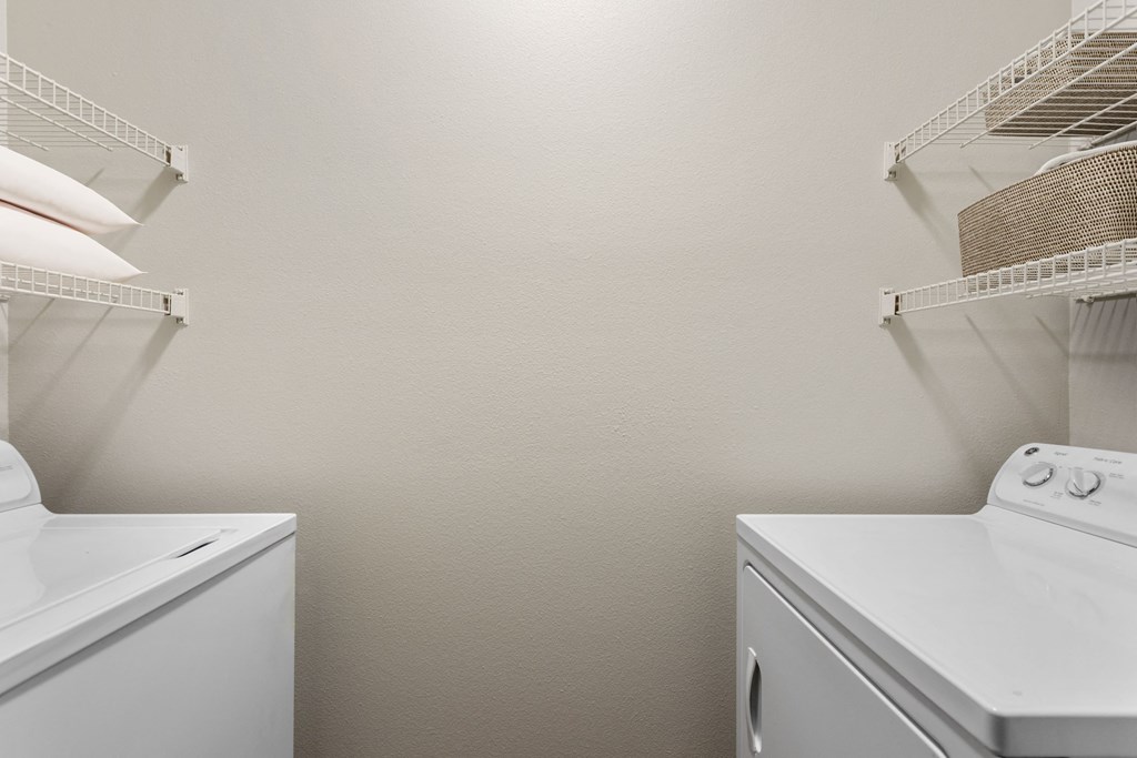 a white washer and dryer in a white laundry room with two white appliances