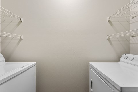 an empty laundry room with two washes and a dryer