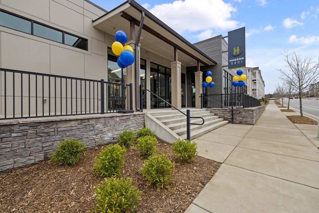 a picture of the front of a building with blue and yellow balloons