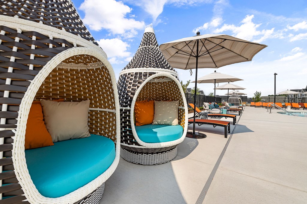 a seating area with wicker chairs and umbrellas