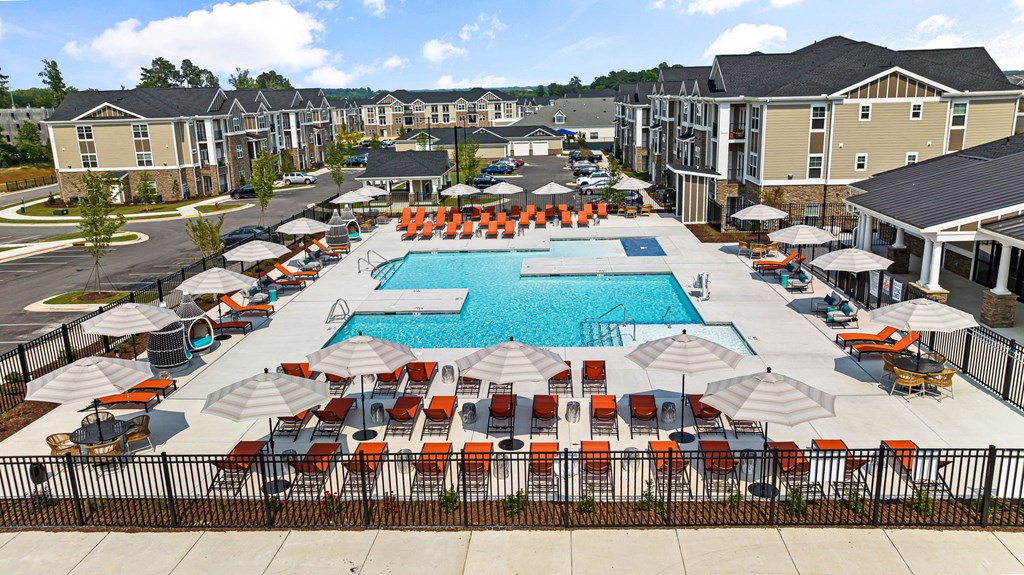 an aerial view of the resort style pool with lounge chairs and umbrellas