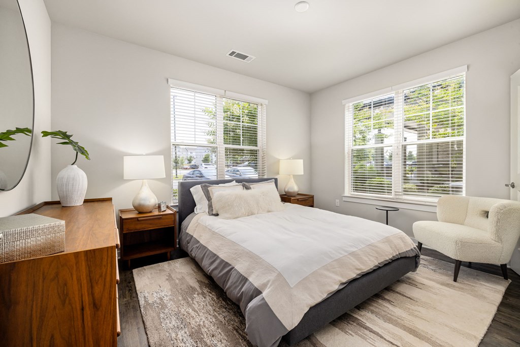 a bedroom with a bed and two windows