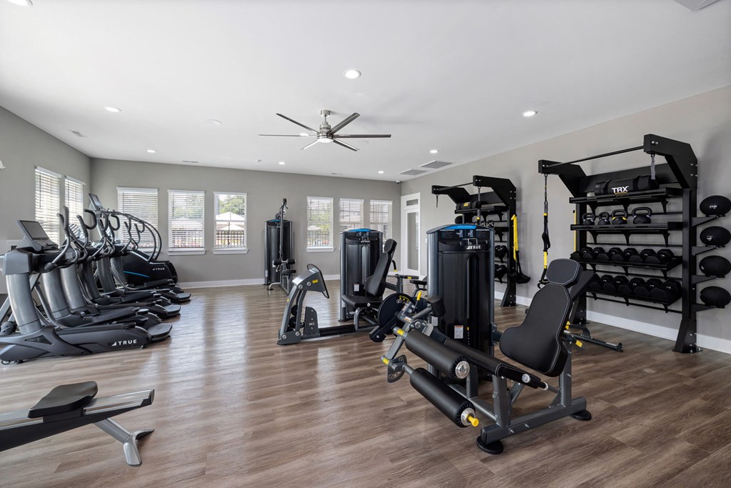 a gym with exercise equipment and a ceiling fan